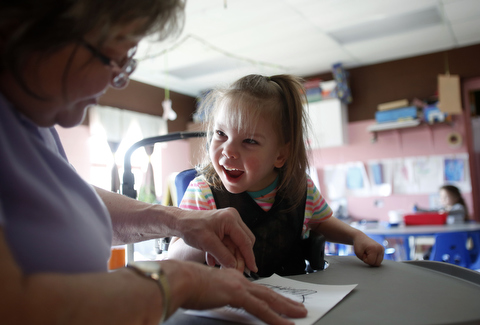 Teacher helping a little girl